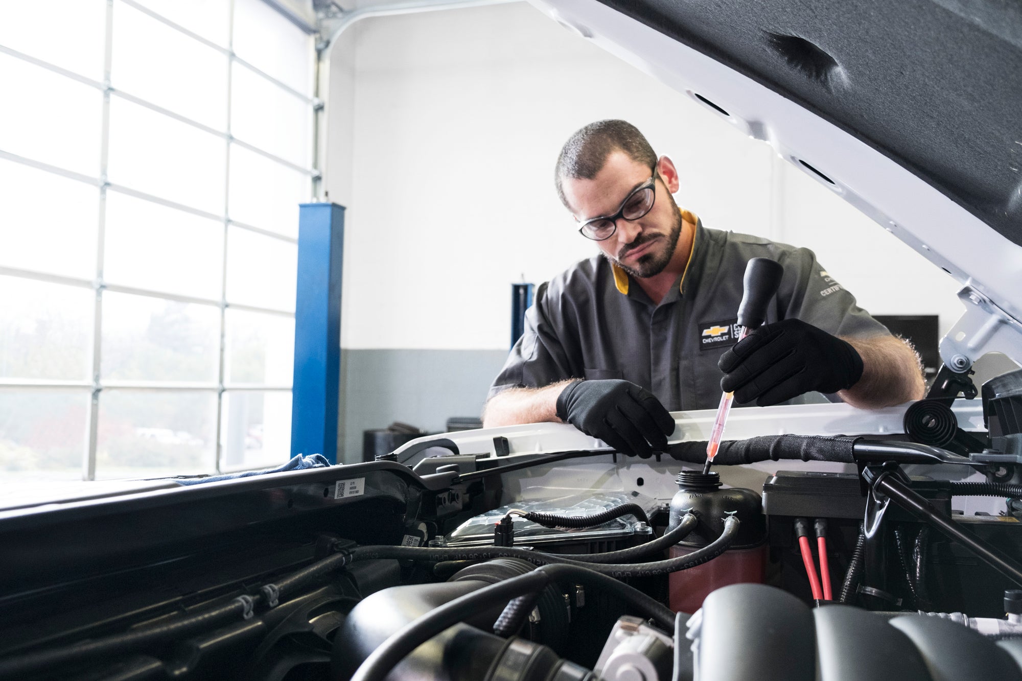 Chevy Service Technician Inspecting Under The Hood